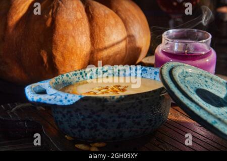 Halloween with candles with pumpkin and cream soup on spooky night - Halloween scene. Stock Photo