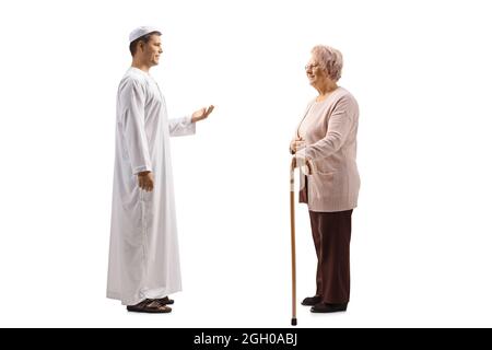 Full length profile shot of a an elderly woman and a young man in ethnic clothes having a conversation isolated on white background Stock Photo