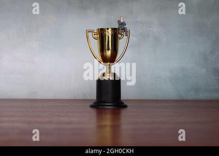 Business concept. Successful businessman sitting on a gold trophy. Selective focus. Copy space for text Stock Photo
