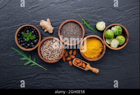 Super foods on in wooden bowl. Selection food and healthy food set up on dark stone background. Stock Photo