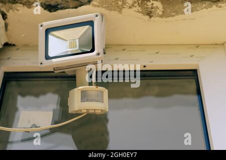 Motion sensor and LED spotlight on the wall of the building. Aut Stock Photo