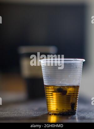 Black glass ashtray with cigarette stubs, butts with ash isolated on white background, top view Stock Photo