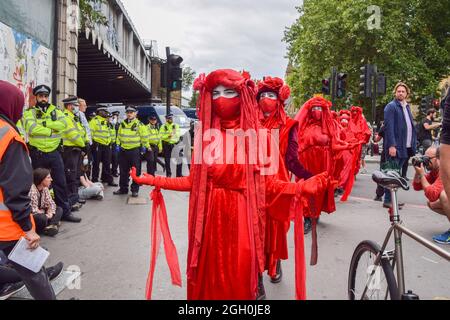 London, United Kingdom. 31st August 2021. Red Rebel Brigade perform at the protest. Extinction Rebellion protesters blocked the streets next to London Bridge with a bus, as part of their two-week Impossible Rebellion campaign. Stock Photo