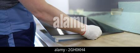 Master installs electric hob on kitchen cabinet Stock Photo