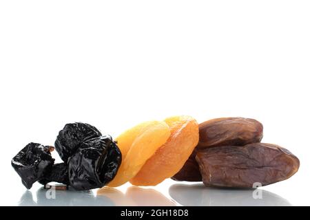 Several appetizing dates, dried apricots, prunes, close-up, isolated on white. Stock Photo