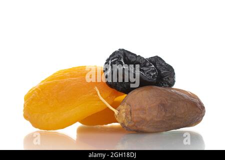 Several appetizing dates, dried apricots, prunes, close-up, isolated on white. Stock Photo
