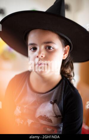 Vertical portrait of caucasian little girl dressed as a witch for Halloween party. Stock Photo