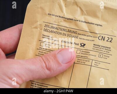 Tambov, Russian Federation - August 23, 2021 A Human hand with an envelope sent via Deutsche Post Stock Photo