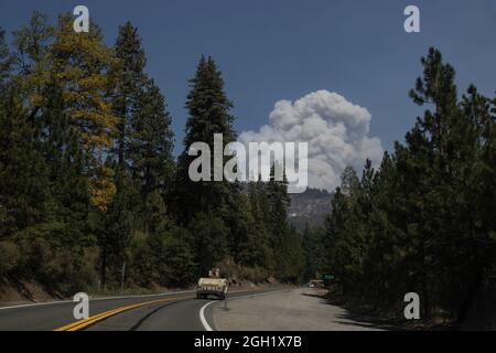A U.S. Army Humvee assigned to the California Army National Guard’s 270th Military Police Company, drives along U.S. Route 50 through Silverfork, California, toward South Lake Tahoe, as a plume of smoke from the Caldor Fire rises above the mountains, Sept. 1, 2021. Cal Guard activated 150 military police Aug. 30 to support the California Highway Patrol with traffic control points at hard road closures while the area around South Lake Tahoe is evacuated. (U.S. Air National Guard photo by Staff Sgt. Crystal Housman)