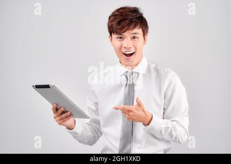 Amazed happy guy holding using digital tablet looking shocked about social media news Stock Photo