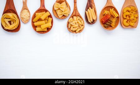 Italian foods concept and menu design. Various kind of Pasta Farfalle, Pasta A Riso, Orecchiette Pugliesi, Gnocco Sardo and Farfalle in wooden spoons Stock Photo