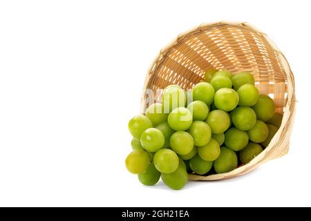 A bunch of green grapes in a weave bamboo basket. Isolated on white background. Stock Photo