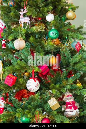 Christmas tree decorated with decorations, ornaments and baubles in a home, UK Stock Photo