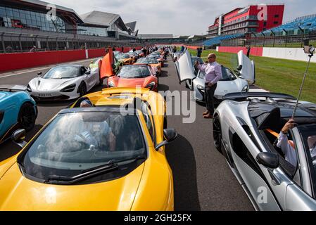 McLaren supercars line up on the starting grid at the Silverstone Circuit for a parade by members of the McLaren Owners Club Stock Photo