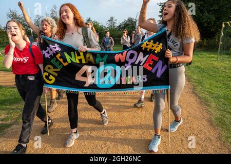 Women arrive at Greenham common gates 40 years after the original march from Cardiff which initiated the Greenham Womens Peace Camp on 5th September 1981. They recreated the march from Cardiff in time for the 40th Anniversary celebrations planned for 5th September 2021. The original Greenham Womens Peace Camp was in opposition to the siting of US nuclear Cruise missiles on the RAF base. Protests continued there throughout the 1980s with attempts to disrupt building the silos and movement of the missiles which were finally removed in 1991. The last women left the camp in 2000 after 19 years. Stock Photo