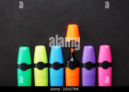 Multi-colored markers in a row on a black background, top view. The concept of creativity and study time Stock Photo