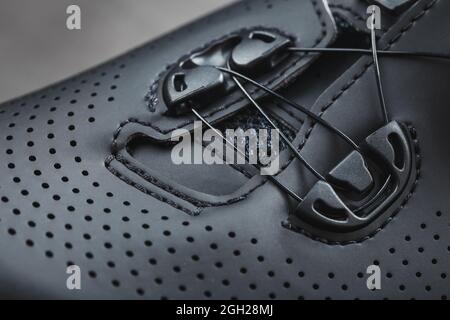 Sports shoes made of black perforated leather in a dark key. Close-up Stock Photo
