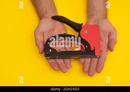 construction stapler gun in the hands. close-up Stock Photo