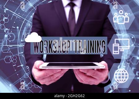 Text sign showing Workshop Training. Concept meaning participants carry out a number of training activities Man In Office Uniform Holding Tablet Stock Photo