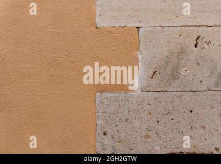 Closeup shot of a stone brick wall - left half painted in orange Stock Photo