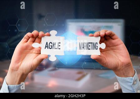 Hand writing sign Agile Marketing. Concept meaning focusing team efforts that deliver value to the endcustomer Business Woman Holding Jigsaw Puzzle Stock Photo