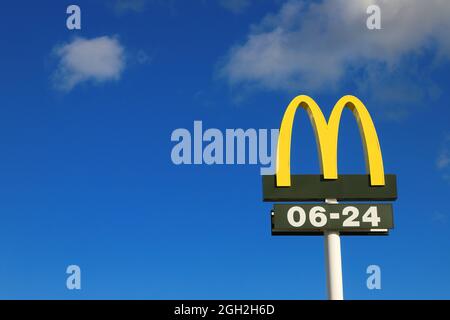 Nykvarn, Sweden - September 4, 2021: Close-up view of McDonald's fast food chain logotype with open hours. Stock Photo