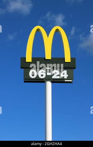 Nykvarn, Sweden - September 4, 2021: Close-up view of McDonald's fast food chain logotype with open hours. Stock Photo