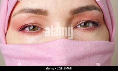 Close-up eyes of a muslim woman wearing a closed hijab Stock Photo