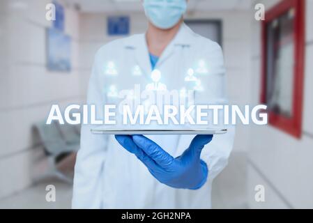 Conceptual caption Agile Marketing. Word for focusing team efforts that deliver value to the endcustomer Man In Uniform Standing Holding Tablet Stock Photo