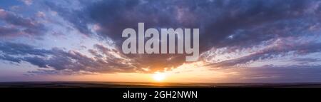 Panorama of a beautiful purple sunset with clouds. Stock Photo