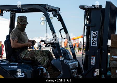 An Airman assigned to Task Force – Holloman maneuvers a forklift as part of Douglas Village construction at Holloman Air Force Base, New Mexico, Sept. 3, 2021. The Department of Defense, through U.S. Northern Command, and in support of the Department of State and Department of Homeland Security, is providing transportation, temporary housing, medical screening, and general support for up to 50,000 Afghan evacuees at suitable facilities, in permanent or temporary structures, as quickly as possible. This initiative provides Afghan evacuees essential support at secure locations outside Afghanista Stock Photo
