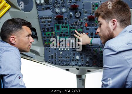 two males in the cockpit discussing about the commands Stock Photo