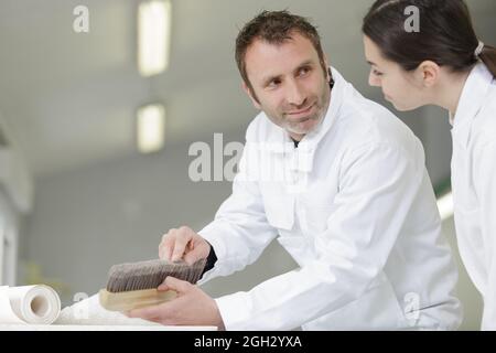 painter teaching paintbrush technique to apprentice Stock Photo