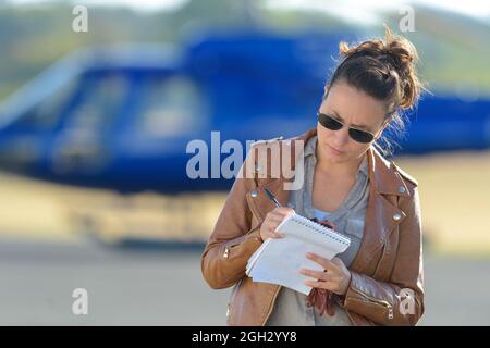 female helicopter pilot taking note Stock Photo