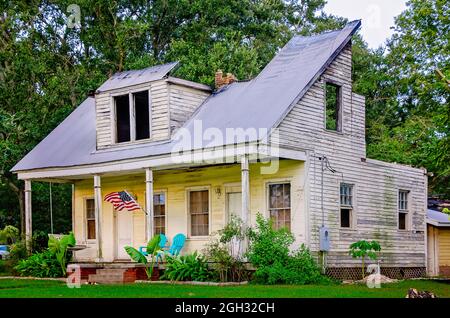 An American flag flies at a fire-damaged house, Aug. 31, 2021, in Bayou La Batre, Alabama. The Creole Plantation-style home is being renovated. Stock Photo