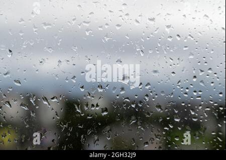 raindrops on window glass, selective focus, rainy city background, texture of raindrops, wet glass Stock Photo