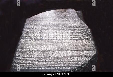 This photo of the Rosetta Stone in the British Museum dates to 1992. Rosetta Stone refers to an ancient Egyptian stone that has inscriptions in several languages and scripts. Their decipherment (credited to French Egyptologist Jean-Francois Champollion) led to the understanding of hieroglyphic writing. The stone is an irregularly shaped stone of black granite 3 feet 9 inches long and 2 feet 4.5 inches wide. It was broken in antiquity, it was found near the town of Rosetta, northeast of Alexandria. It was discovered by a Frenchman named Bouchard or Boussard in August 1799. After the French surr Stock Photo