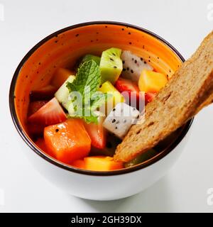 mixed fresh fruit bowl includes kiwi, berries, papaya, dragonfruit, melon etc. Stock Photo