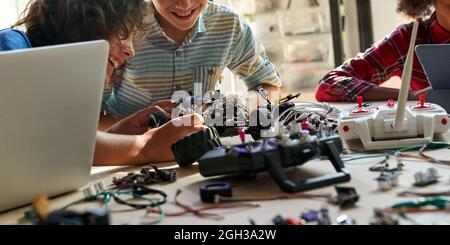 School kids boys helping building robotic car learning together at STEM class. Stock Photo
