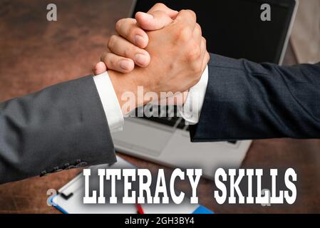 Writing displaying text Literacy Skills. Internet Concept all knowledge and skills need to evaluate information Two Professional Well-Dressed Stock Photo