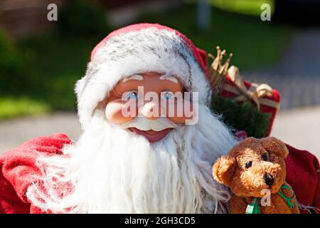 a large Santa doll on display in the middle of summer Stock Photo