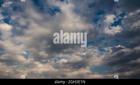 dramatic gray clouds in a blue sky Stock Photo