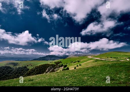 panorama of the beautiful countryside. sunny afternoon. beautiful spring landscape in the mountains. grassy field and hills. rural landscapes Stock Photo