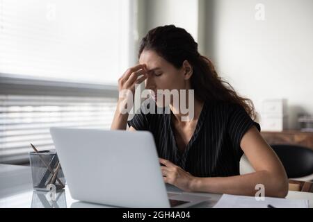Sad frustrated millennial woman tired of work at computer Stock Photo