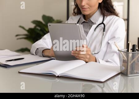 Female physician using tablet computer, giving online virtual consultation Stock Photo