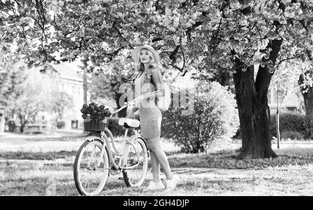 Active day. cherry tree pink blossom. perfect smell. perfume spa and allergic. travel. retro woman sell tulip flower bouquet. girl under sakura with Stock Photo