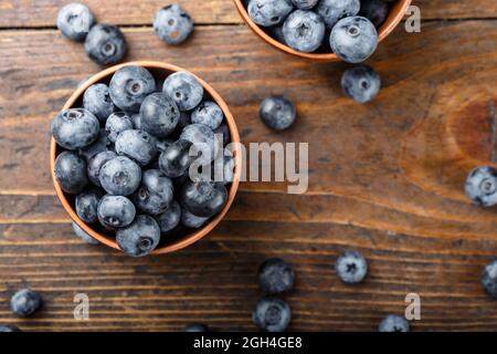 Freshly picked blueberries in a clay bowl. Healthy berry, organic food, antioxidant, vitamin, blue food. Stock Photo