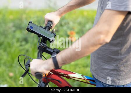 Man planning route using GPS navigation application in mobile phone on his bicycle bike Stock Photo
