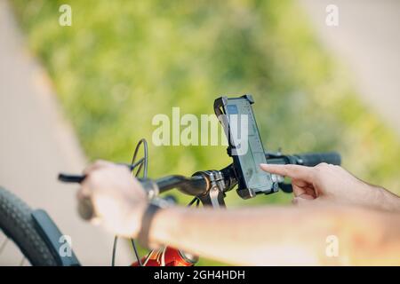 Man planning route using GPS navigation application in mobile phone on his bicycle bike Stock Photo