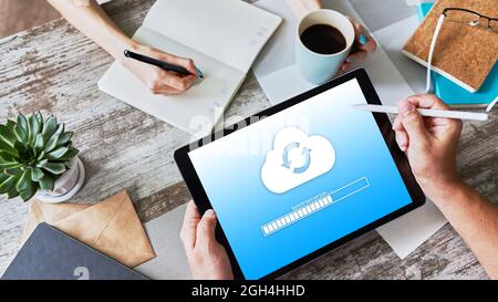 Cloud synchronization progress bar on tablet screen. Data storage and protection. Technology and internet concept Stock Photo